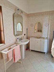 een badkamer met een wastafel en een spiegel bij La Cava di Sasà in Favignana