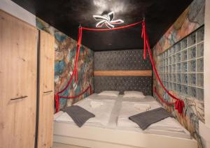 Bett in einem Zimmer mit Wandgemälde in der Unterkunft Resort TimAJA - pool, massage pool, sauna in Trebnje