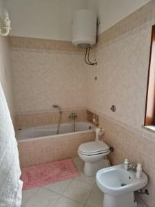 a bathroom with a toilet and a tub and a sink at La Cava di Sasà in Favignana