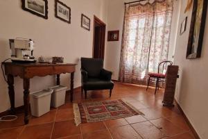 a living room with a chair and a table and a coffee machine at La Cava di Sasà in Favignana