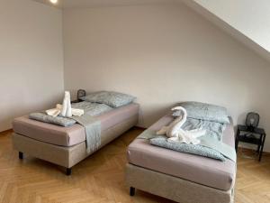 two beds with white swans on them in a room at Comfortable Shared Apartment with Private Room in Wesseling in Wesseling