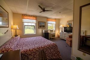 a bedroom with a bed and a flat screen tv at The Presidential Inn at Poland Spring Resort in Poland