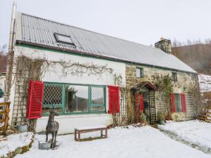 a house with a deer statue in the snow at The Old Mill in Beauly