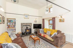 a living room with two couches and a fireplace at The Old Mill in Beauly
