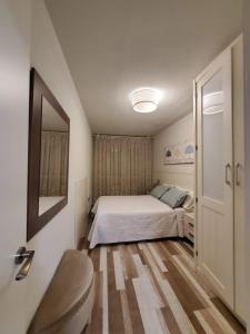 - une petite chambre avec un lit et un miroir dans l'établissement Alojamiento en Villamayor, à Villamayor
