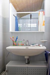 ein Badezimmer mit einem weißen Waschbecken und einem Spiegel in der Unterkunft Ski-in Apartment in Anzere in Anzère