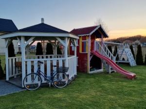 a bike parked in front of a gazebo and a playground at Baltic Stone in Rewal