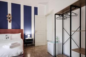 a bedroom with a blue and white striped wall at 2 Santi - Suite and Rooms in Lecce