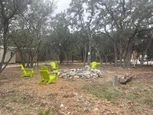 a group of green chairs around a fire pit at River Dreams Cabins & Glamping in Concan