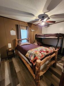 a bedroom with a bed with a ceiling fan at River Dreams Cabins & Glamping in Concan