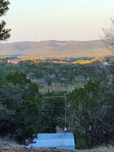 a view of a hill with trees and a building at River Dreams Cabins & Glamping in Concan