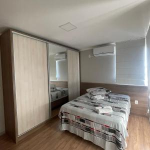 a bedroom with a bed and a large mirror at Apartamento aconchegante novo in Bento Gonçalves