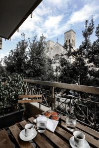 a table with cups and plates of food on a balcony at 2 Santi - Suite and Rooms in Lecce