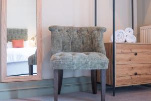 a chair in a bedroom next to a mirror at Woodroffe Arms, Hope Twin Room 5 in Hope