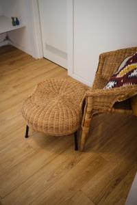 a wicker chair in a room with a wooden floor at סוויטת סטודיו במתחם נוֺגה in Tel Aviv