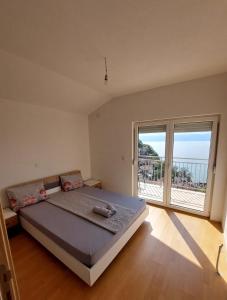 a bedroom with a large bed and a large window at Indijano Apartment in Ohrid