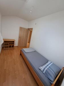 a bedroom with a bed and a wooden floor at Indijano Apartment in Ohrid
