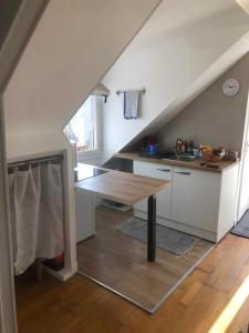 an attic kitchen with a table and a counter top at Grand studio aéré entre sol in Montreuil