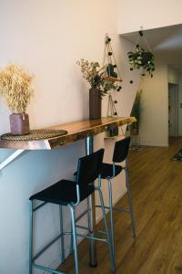 een bar met drie stoelen en een bar met planten bij סוויטת סטודיו במתחם נוֺגה in Tel Aviv