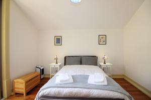 a bedroom with a bed and two side tables at Casa 11 Cravos in Figueira da Foz