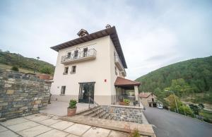 een wit huis met een balkon en een heuvel bij Casa Aurita in Ansó