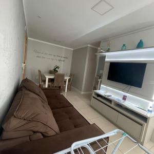 a living room with a couch and a flat screen tv at Apartamento aconchegante novo in Bento Gonçalves
