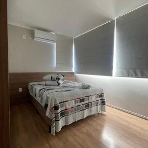 a bedroom with a bed in a room with a window at Apartamento aconchegante novo in Bento Gonçalves