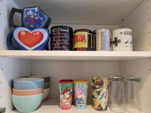 a shelf filled with cans and plates and bowls at ☆ NintendMeaux ☆ Disneyland ☆ Family ☆ Quite ☆ Netflix & Disney+ ☆ in Meaux