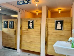 een badkamer met houten deuren, een wastafel en een spiegel bij Hotel and Beach Club Escape Holbox in Holbox Island