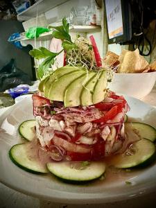 een sandwich op een bord met komkommers op een tafel bij Hotel and Beach Club Escape Holbox in Holbox Island