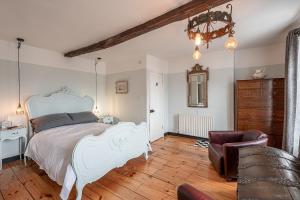 a bedroom with a white bed and a chair at Moonfleet Guest House in Skinningrove