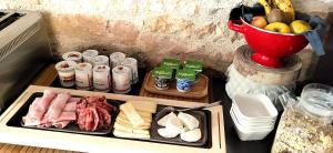 a tray of food with meats and cheese and a bowl of fruit at La Tissandière in Lalbenque