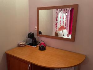 a mirror on a wall above a wooden table at Family hotel Deykin in Sunny Beach