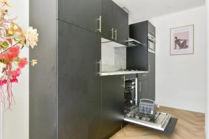 una cocina con un armario negro con un aparato en De Goudiep Eco Lodge, en Ermelo