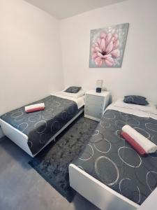 two beds sitting next to each other in a bedroom at Apartman Stipančić in Labin