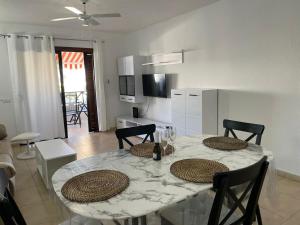 stół w jadalni z dwoma krzesłami i kuchnia w obiekcie Under The Lime, beautiful apartment Los Cristianos w mieście Los Cristianos