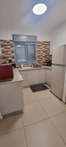 een keuken met witte kasten en een koelkast bij Shoham apartment in Eilat