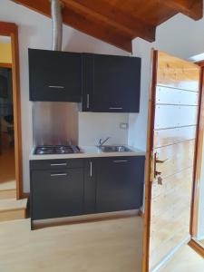 uma cozinha com um fogão e um lavatório ao lado de uma porta em Roccetta Fiorita em Pettenasco