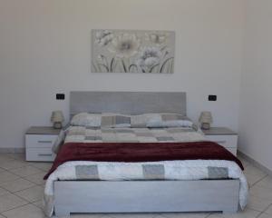 1 dormitorio con 1 cama con una pintura floral en la pared en Casa Iole, en Montepulciano