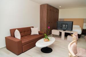 sala de estar con sofá marrón y TV en Hotel Explore Caño Dulce, en Tubará
