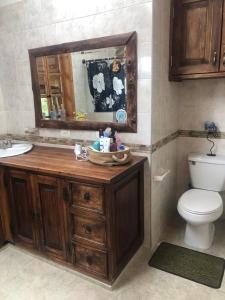 a bathroom with a sink and a toilet and a mirror at Casa Campestre EL CAPRICHO Fúquene in Fúquene