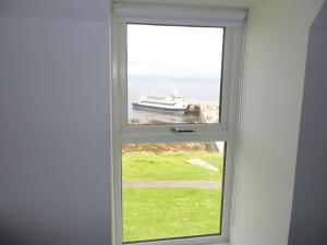 a window with a view of a boat in the water at Buckie - 1 Bedroom with ensuite in Wick