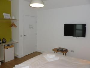 a bedroom with a bed and a flat screen tv on the wall at Buckie - 1 Bedroom with ensuite in Wick