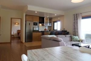 a living room with a white couch and a kitchen at Panorama Apartment Sagres *Pool* in Sagres
