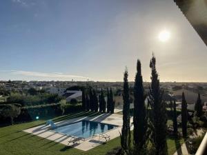 a swimming pool in a yard with cypress trees at Panorama Apartment Sagres *Pool* in Sagres