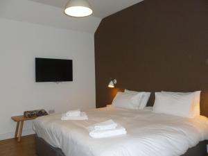 1 dormitorio con 1 cama blanca y TV en la pared en Portknockie - 1 Bed Room with Ensuite en Wick