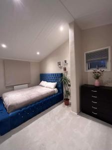 a bedroom with a blue bed and a dresser at Family home in Northampton