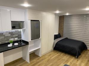 a small bedroom with a bed and a kitchen at 5924 LOFT in Bogotá