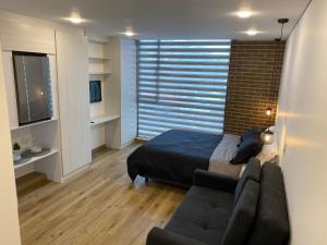 1 dormitorio con cama, sofá y TV en 5924 LOFT, en Bogotá