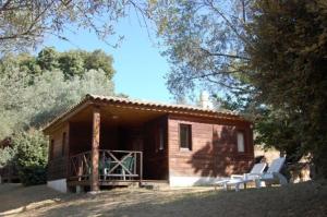 a small cabin with two white chairs in front of it at Gites Chalets de Grosseto-Prugna in Grosseto-Prugna